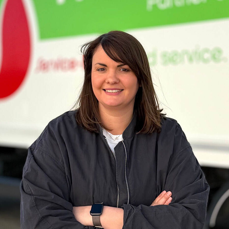 Mareike Eine Frau steht lächelnd vor einem Lastwagen.