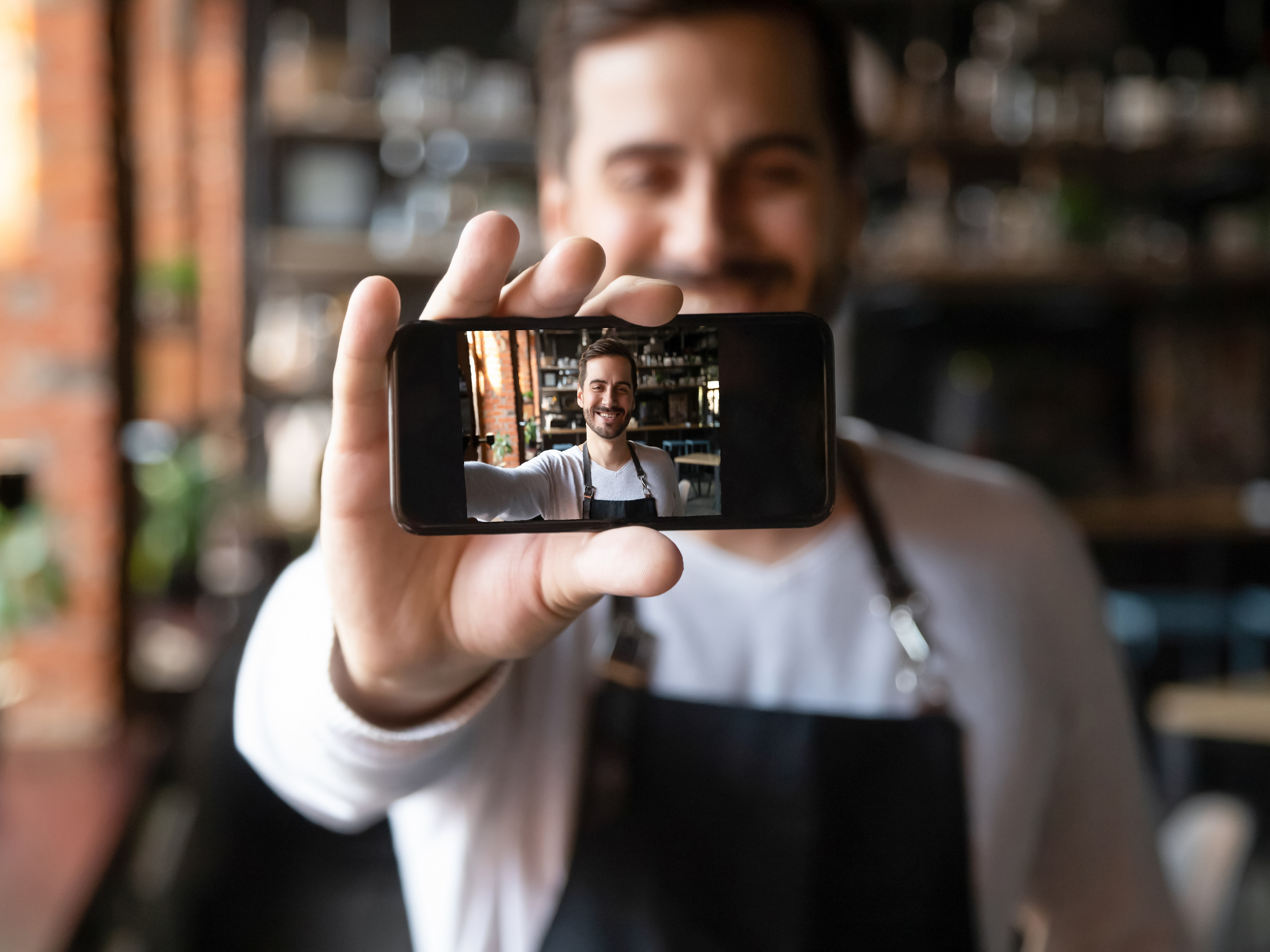 Mann hält Smartphone hoch