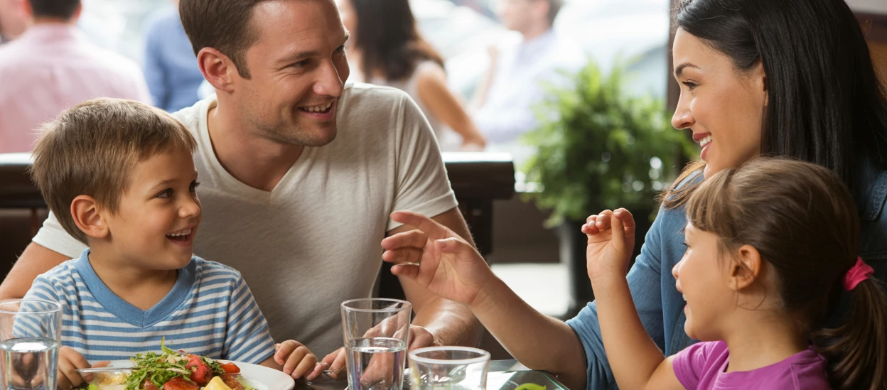 Weltkindertag Ein Mann und eine Frau mit Kindern an einem Tisch mit Essen.