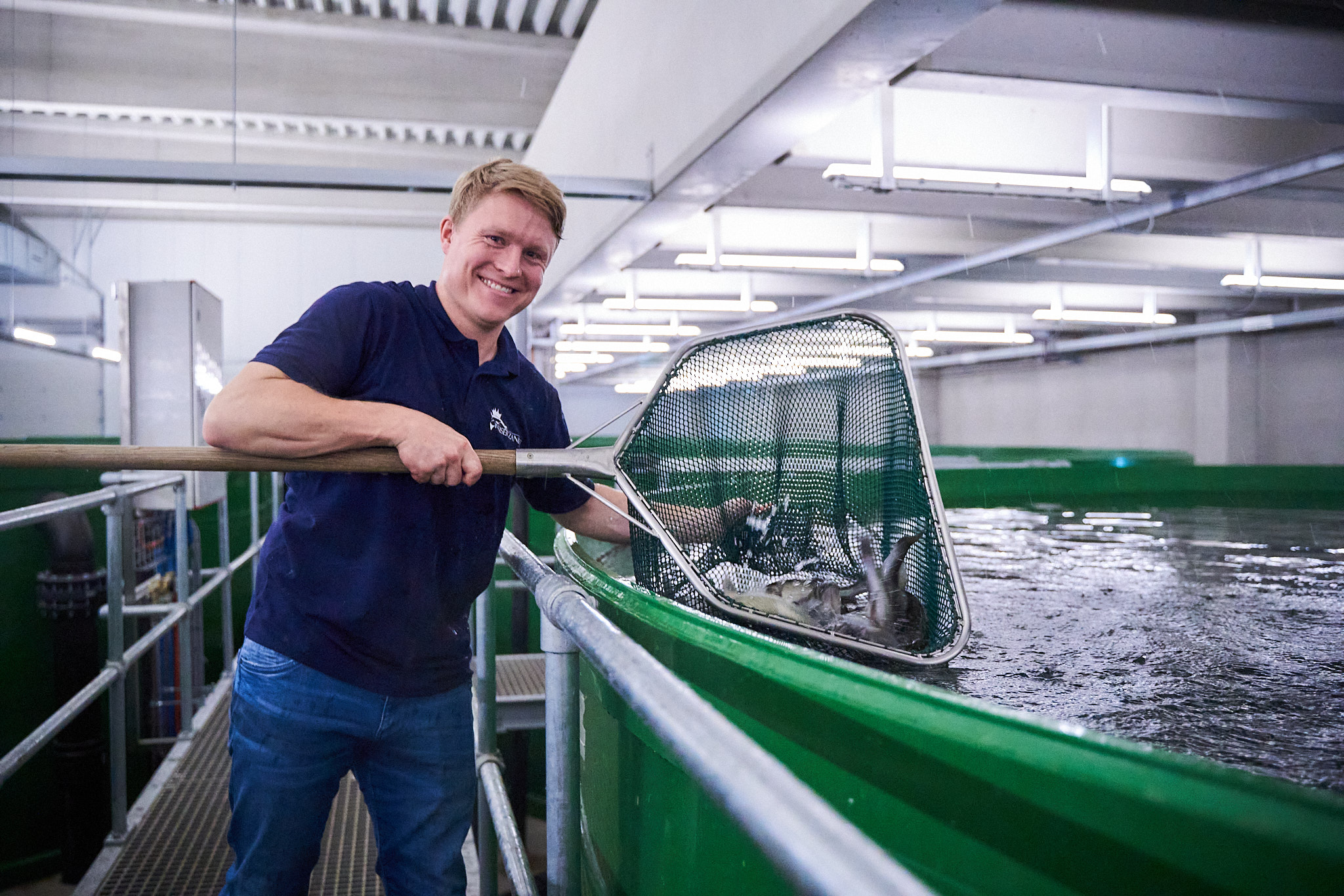 Mann fischt Zander aus Becken