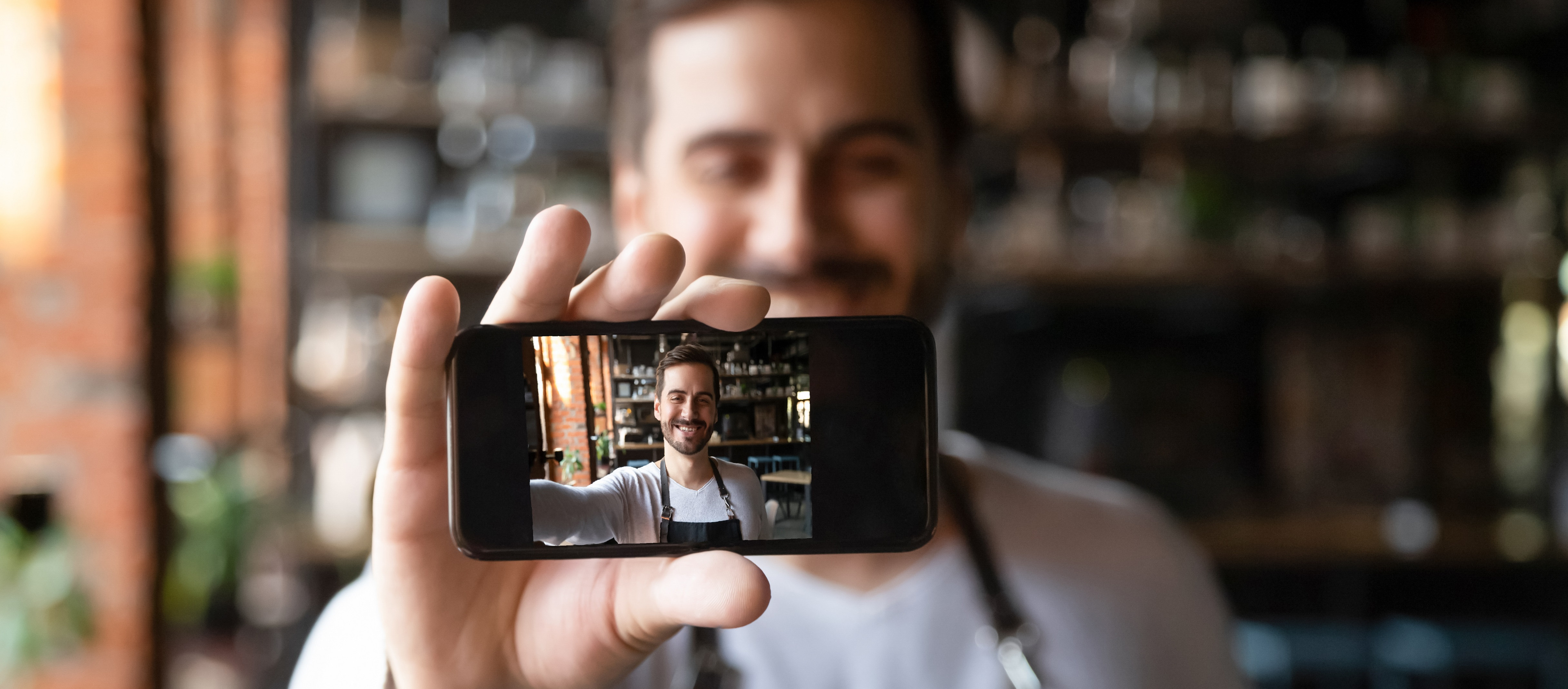 Mann hält Smartphone hoch