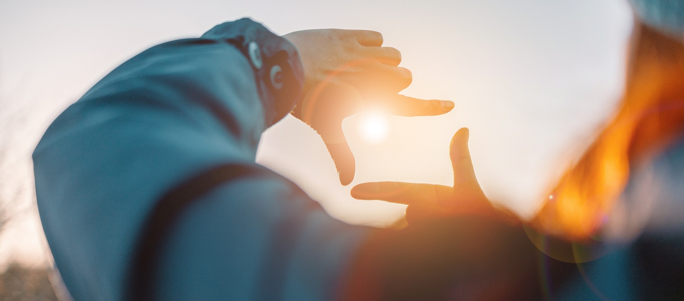 Eine Hand einer Person streckt sich zum Himmel.
