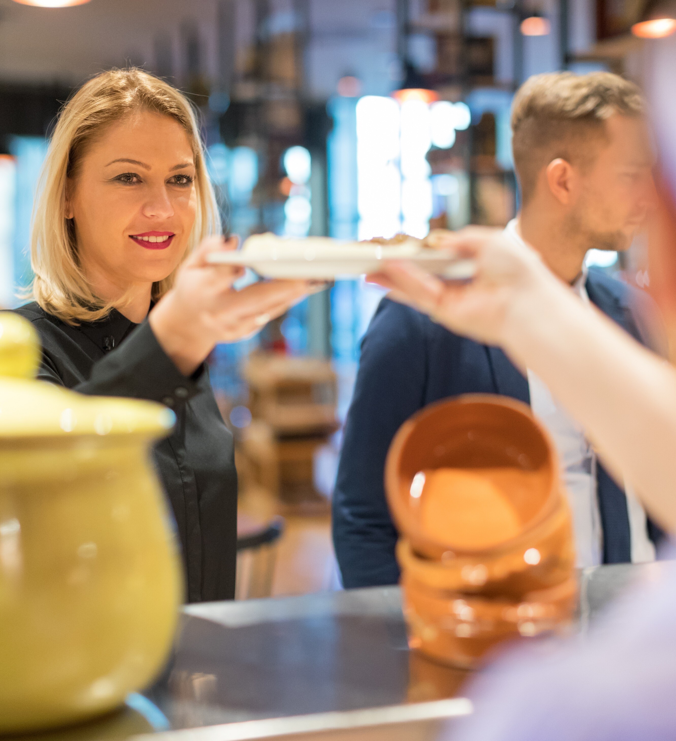 Betriebsgastronomie Eine Frau bekommt einen Teller überreicht