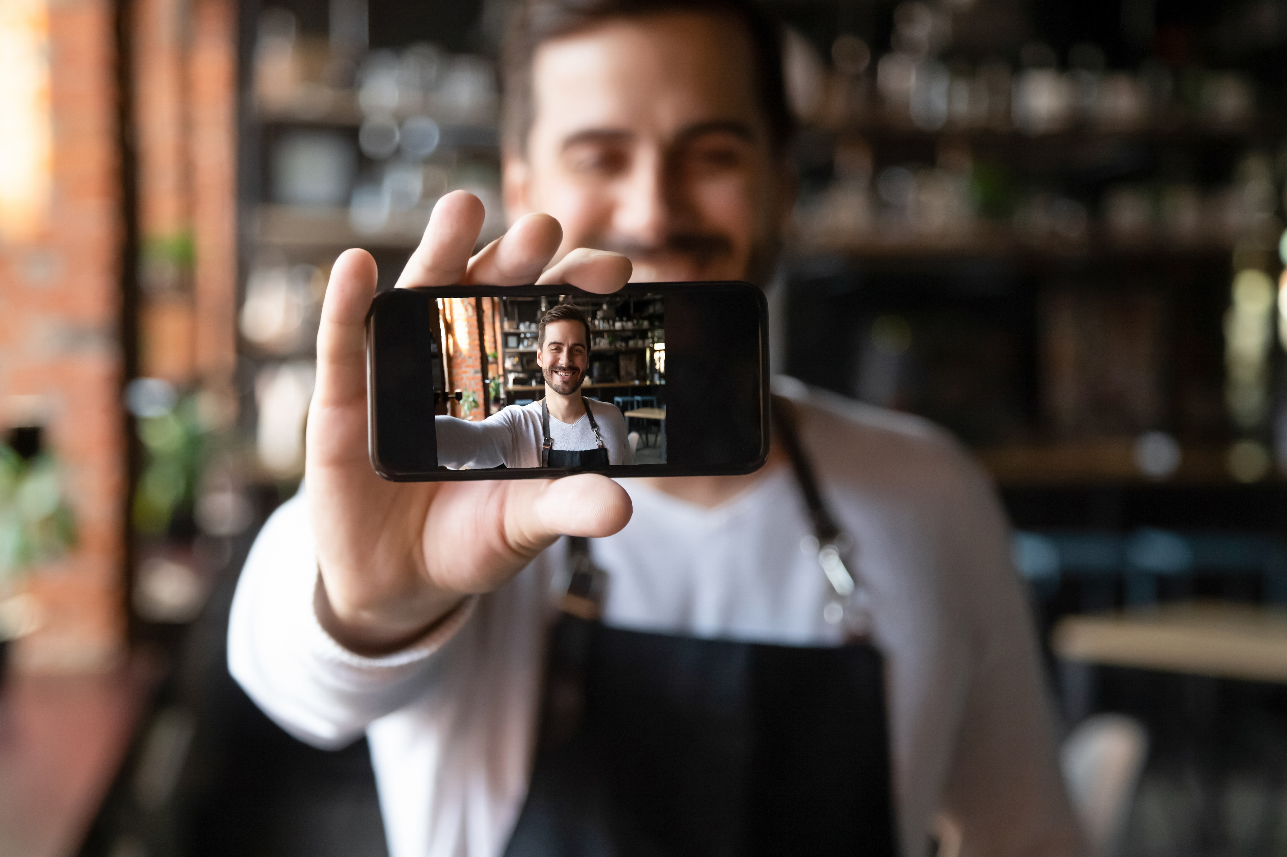 Mann hält Smartphone hoch