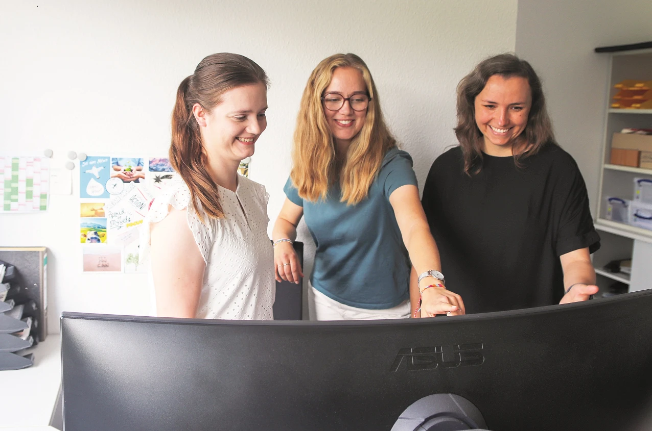Eine Gruppe von Frauen steht vor einem Computer.