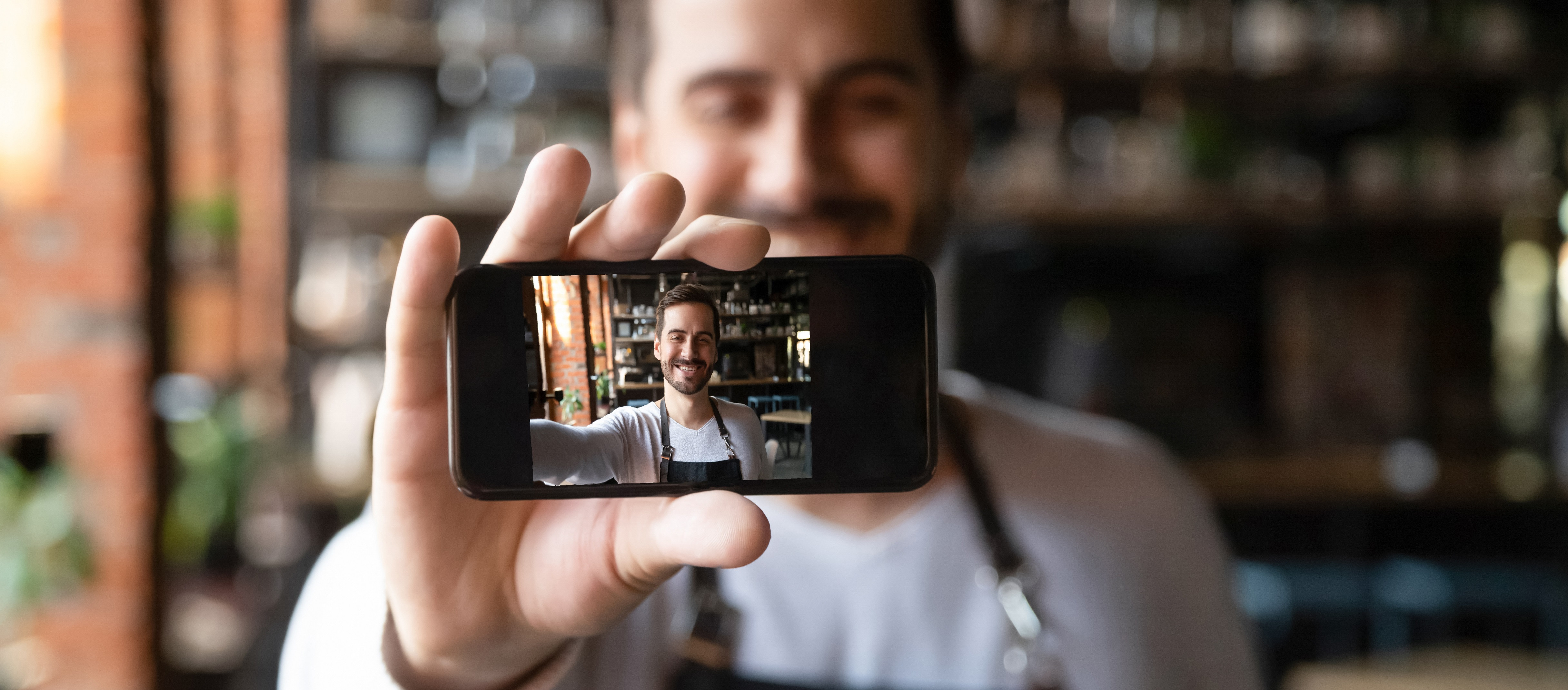 Digital Ein Mann hält ein Mobiltelefon.
