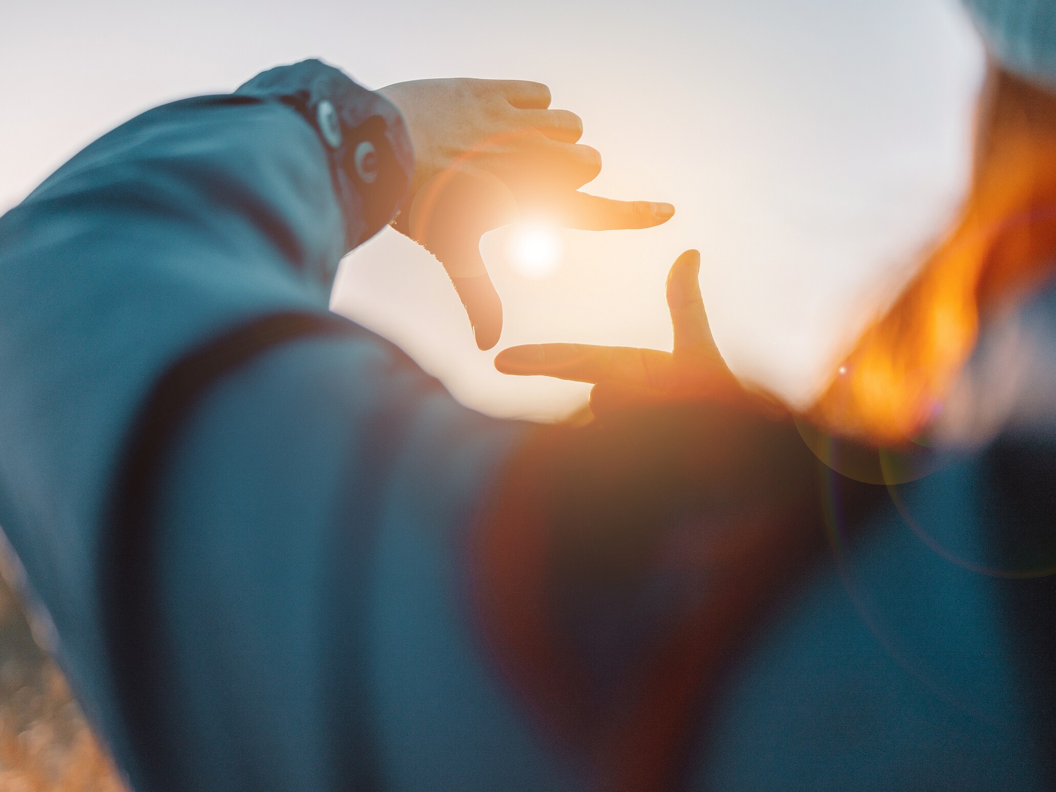 Eine Hand einer Person streckt sich zum Himmel.