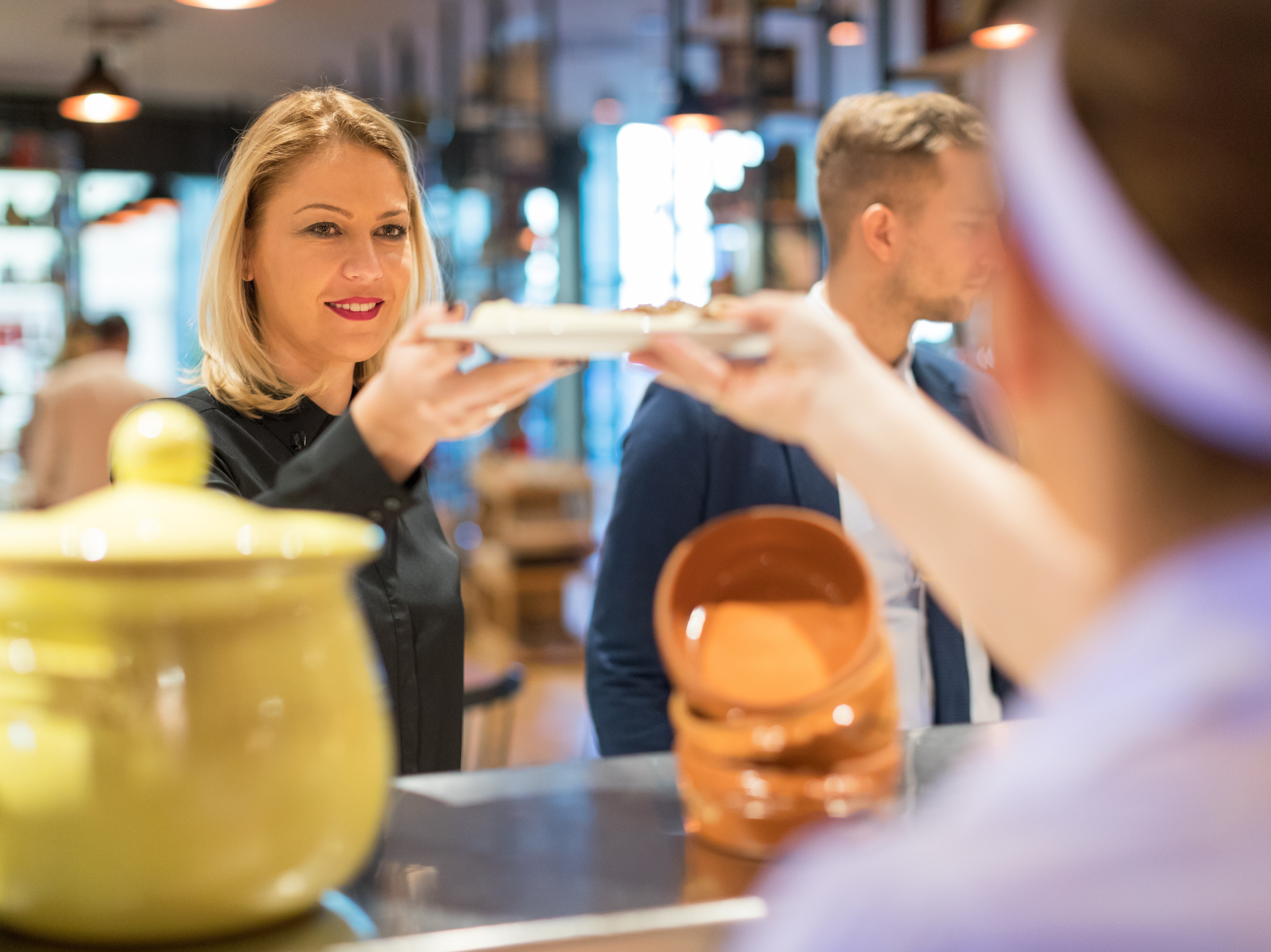 Betriebsgastronomie Eine Frau hält einen Teller.