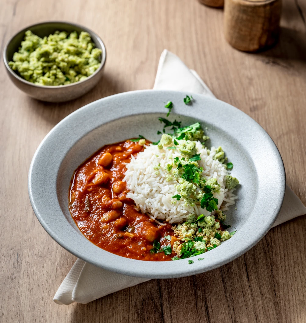 Eine Schüssel mit Gemüse und Soßen auf einem Tisch.