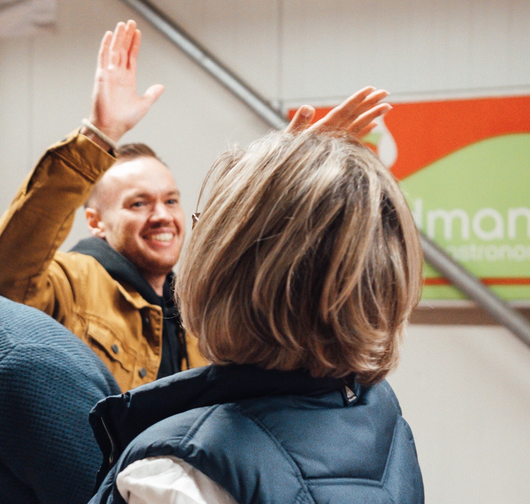 Eine Gruppe von Menschen in einem Raum, einige lächelnd, mit legerer Kleidung.