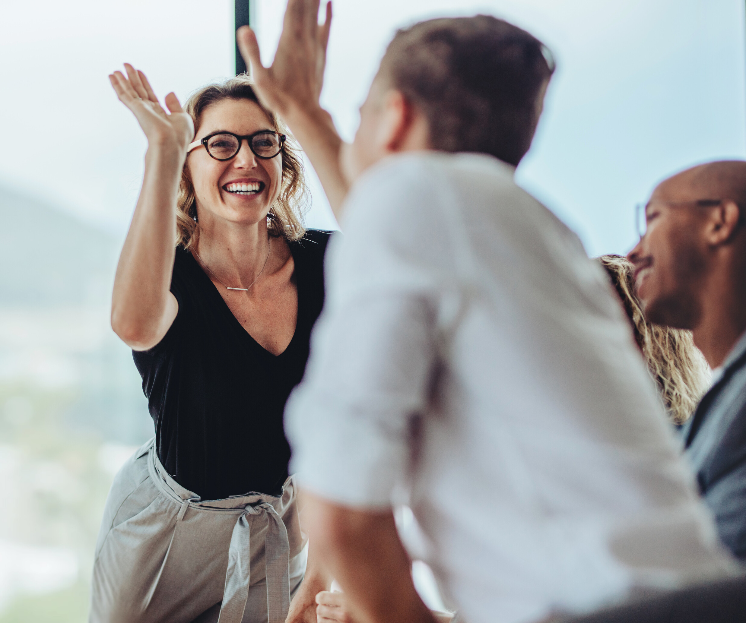 Eine Frau mit erhobenen Händen und ein Mann mit Brille.